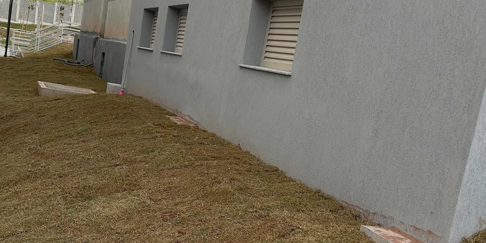 Grama recém-plantada em faixa ao longo da fachada do Fórum de Barbacena